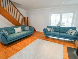 A living room with two sofas and a rug at Too Hoots in Lligwy