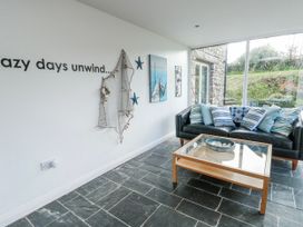 A snug with a sofa and coffee table at Too Hoots in Lligwy