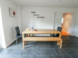 A dining room with a table and chairs at Too Hoots in Lligwy