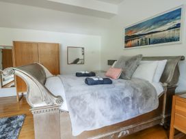 A bedroom with a bed and wardrobe at Too Hoots in Lligwy