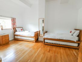 A bedroom with two beds and a mirror at Too Hoots in Lligwy