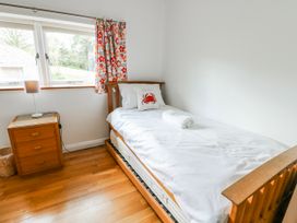 A bedroom with a single bed and nightstand at Too Hoots in Lligwy