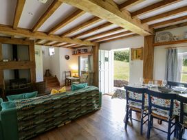 A living room with a sofa and dining area at Cynefin in Newport, Pembrokeshire