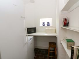 A kitchen with a refrigerator, countertop, and microwave at Cynefin in Newport, Pembrokeshire