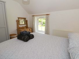 A bedroom with a bed and a dresser at Cynefin in Newport, Pembrokeshire