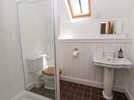 A bathroom with a shower, toilet, and sink at Cynefin in Newport, Pembrokeshire