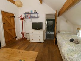 A bedroom with a bed and television at Cynefin in Newport, Pembrokeshire