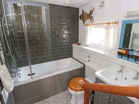 A bathroom with a shower and bathtub at Cynefin in Newport, Pembrokeshire