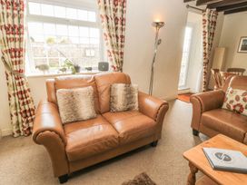 A living room with a sofa and curtains at Shepherds Nook in Chathill