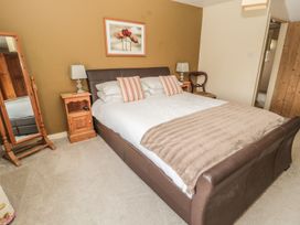 A bedroom with a bed and a mirror at Shepherds Nook in Chathill