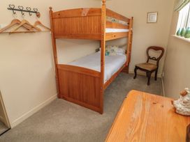 A bedroom with a bunk bed and a chair at Shepherds Nook in Chathill