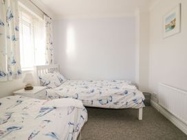 A bedroom with two beds and a bedside table at Seahorses in Padstow
