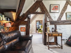A living room with a leather sofa and a wooden table at Plas Dolguog in Machynlleth