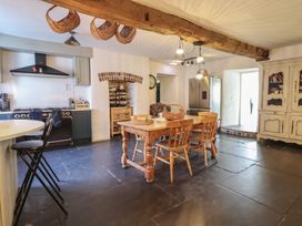 A kitchen with a dining table and stove at Plas Dolguog in Machynlleth