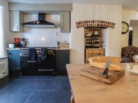 A kitchen with oven, cutting board, and bread at Plas Dolguog in Machynlleth