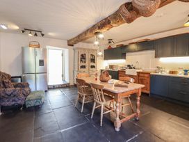 A kitchen with a table and chairs at Plas Dolguog in Machynlleth