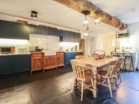 A kitchen with a dining table and chairs at Plas Dolguog in Machynlleth