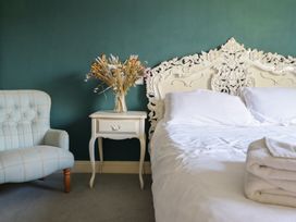 A bedroom with a bed and a bedside table at Plas Dolguog in Machynlleth