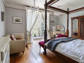 A bedroom with a four-poster bed and a dresser at Plas Dolguog in Machynlleth