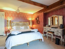 A bedroom with a large bed and dresser at Plas Dolguog in Machynlleth