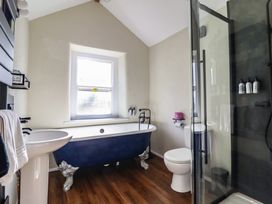 A bathroom with a bathtub and sink at Plas Dolguog in Machynlleth