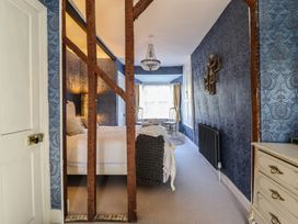 A bedroom with a bed and chandelier at Plas Dolguog Machynlleth