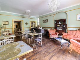 A lounge with tables and seating at Plas Dolguog in Machynlleth