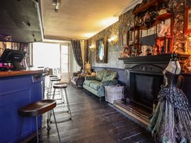 A living room with a bar area and a fireplace at Plas Dolguog in Machynlleth