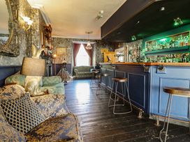 A lounge with a bar and seating area at Plas Dolguog in Machynlleth