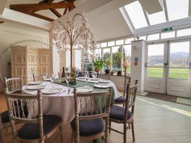 A dining room with a large table and chairs at Plas Dolguog in Machynlleth