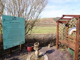 An outdoor area with a sign and a bench at Plas Dolguog in Machynlleth