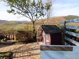 A garden with a playhouse and gnomes at Plas Dolguog in Machynlleth