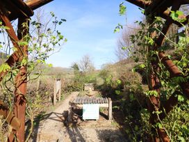 A garden pathway leading to a bench and gazebo at Plas Dolguog in Machynlleth