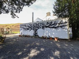 An outdoor area with a tree mural on the wall at Plas Dolguog in Machynlleth