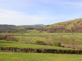 A landscape view with hills and fields at Plas Dolguog in Machynlleth
