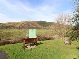 A bench and sign in an outdoor area with hills in the background at Plas Dolguog, Machynlleth
