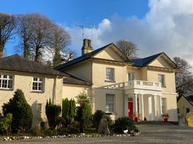 A house with a red door and trees at Lakeview Villa near Liskeard