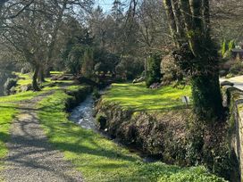 A path alongside a stream and trees at Lakeview Villa near Liskeard
