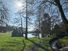 A park with trees, a pond, and a pathway at Lakeview Villa near Liskeard