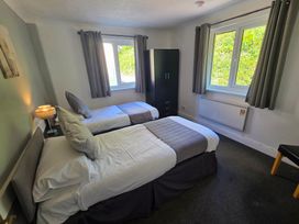 A bedroom with two beds and a wardrobe at Lakeview Villa near Liskeard