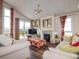 A living room with a TV and a fireplace at 8 Summerleaze in Bude