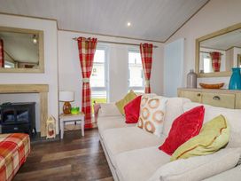 A living room with a sofa and decorative items at 8 Summerleaze in Bude