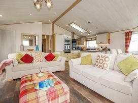 A living room with sofas and a table at 8 Summerleaze in Bude