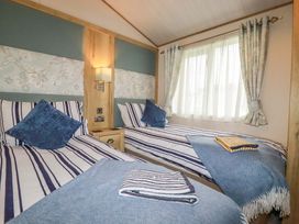 A bedroom with two beds and a side table at 8 Summerleaze in Bude