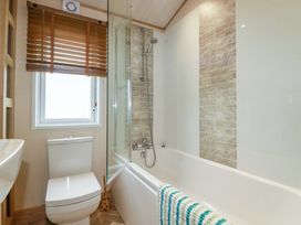 A bathroom featuring a toilet, shower, and bathtub at 8 Summerleaze in Bude