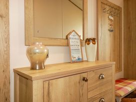 A hallway with a cabinet and mirror at 8 Summerleaze in Bude