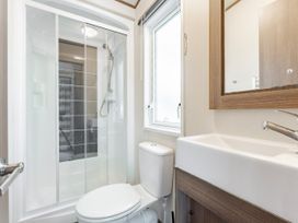 A bathroom with a shower, toilet, and sink at Fern View -Kelling Heath Holiday Park in Weybourne near Sheringham