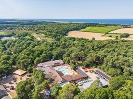 An aerial view of a holiday park with a pool and surrounding nature at Fern View -Kelling Heath Holiday Park in Weybourne near Sheringham