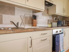 A kitchen with a sink, draining rack, and kettle at Flat 5 in Looe