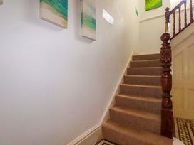 A staircase with carpet and wall paintings at Flat 5 in Looe